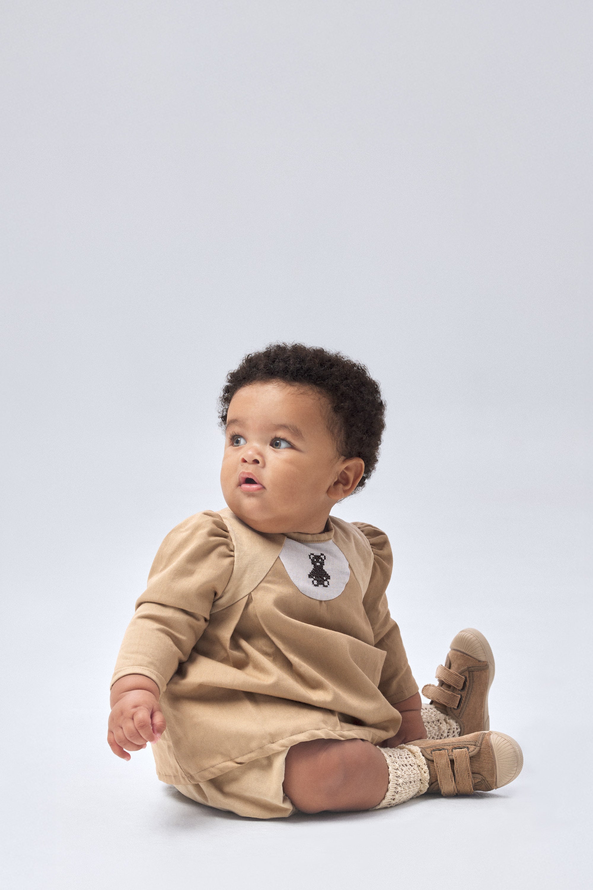 Modelo bebé con El conjunto Harper color avellana, elegancia y atemporalidad, combinación perfecta para los más pequeños.