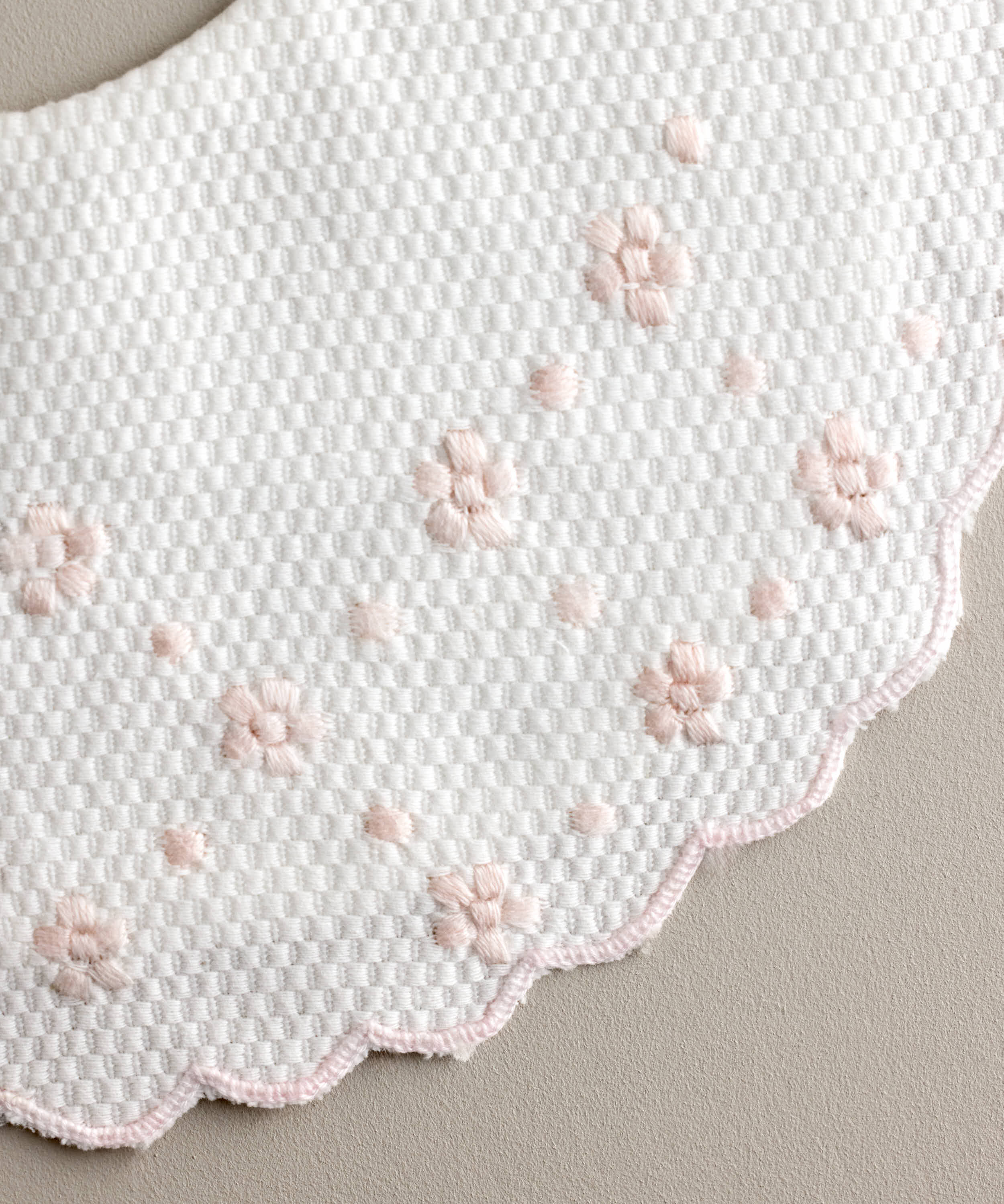 Detalle Babero redondo pique bordado en color rosa empolvado de flor y bodoque. Ref 480RPK