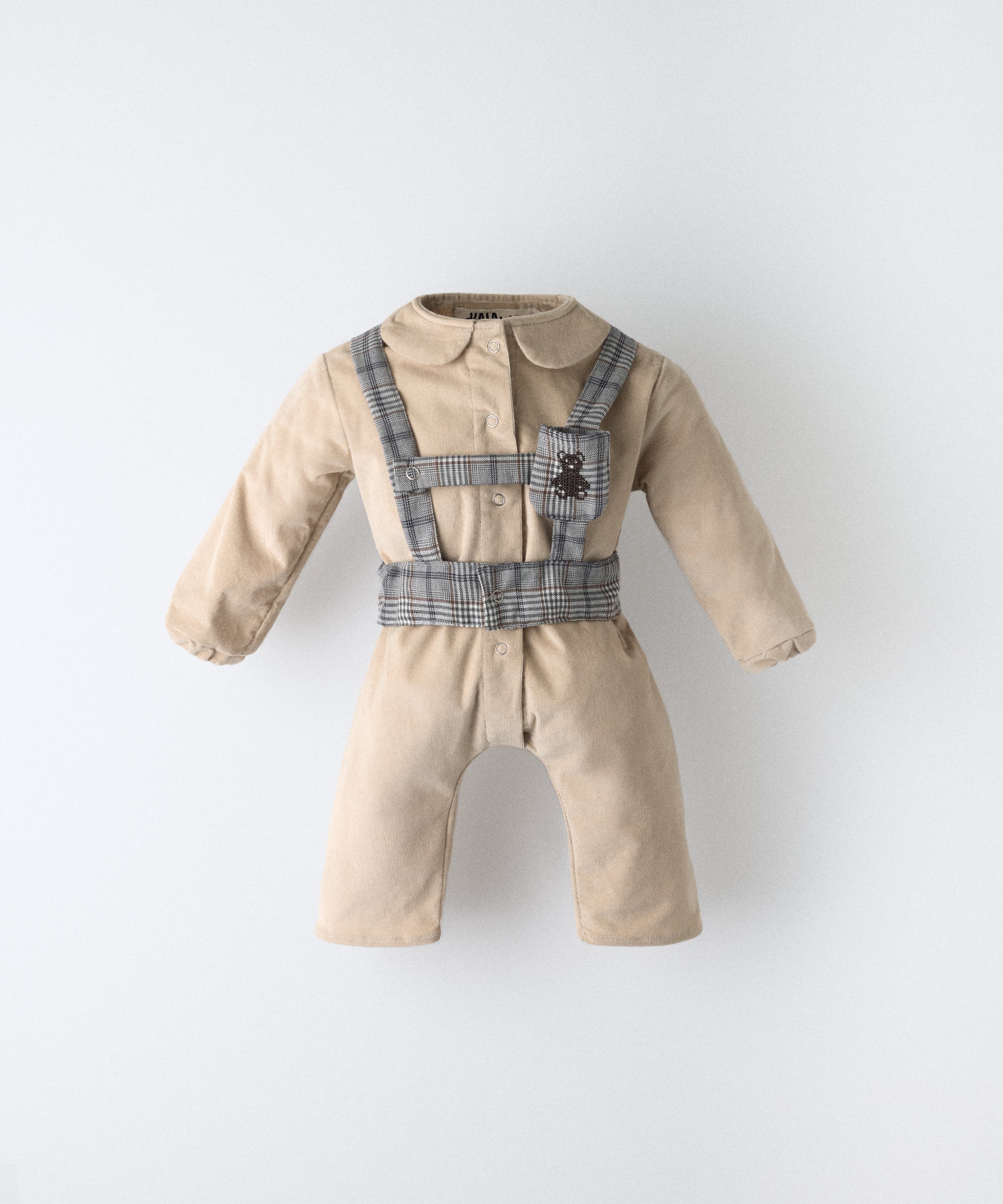 Jumpsuit bebé beige de pana BCI con arnés GRS, cuello estructurado y logo bordado Kala.