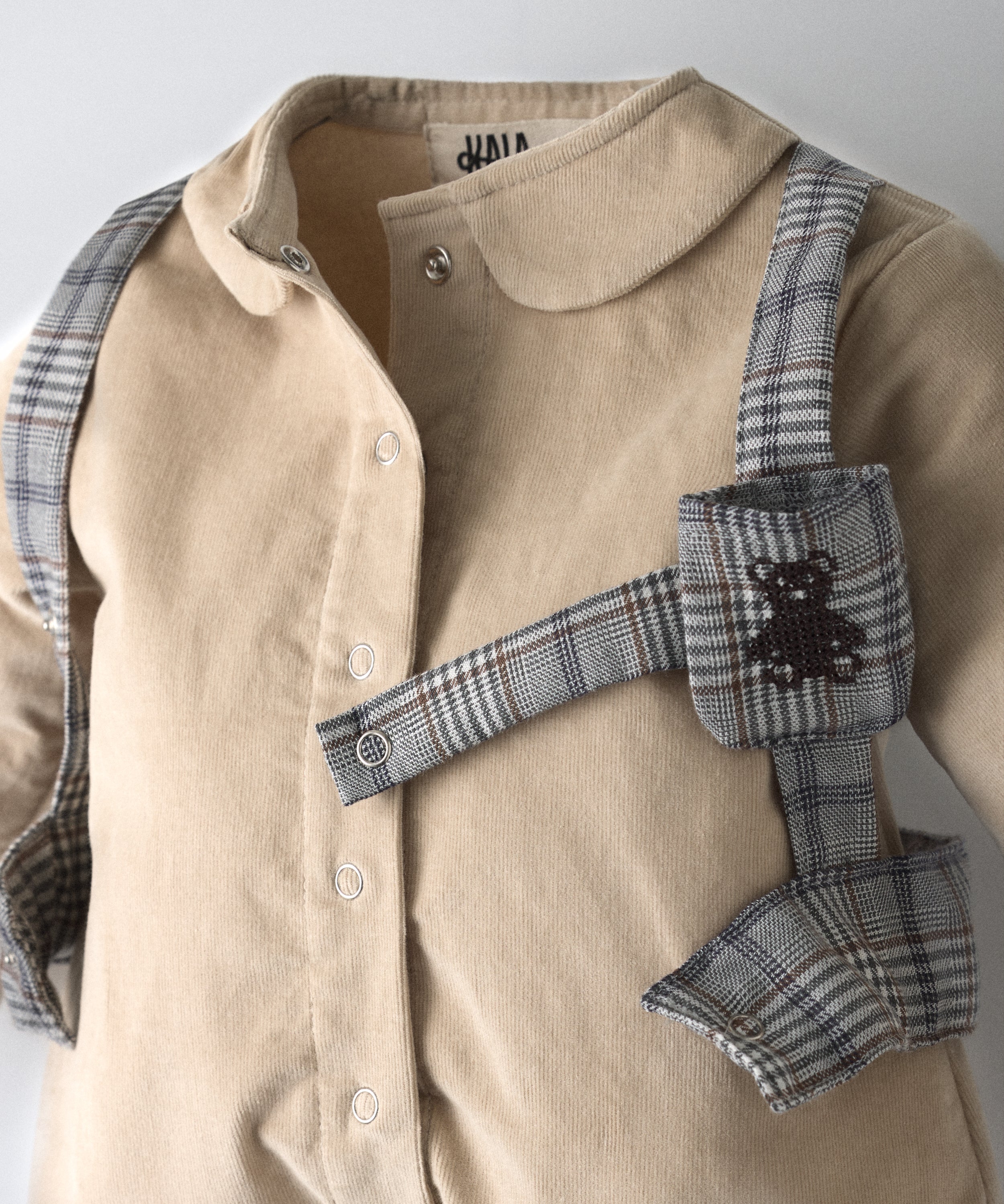 Detalle del arnés en tejido GRS abierto con bolsillo para chupete y logo bordado.