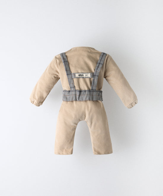 Vista trasera del jumpsuit bebé beige de pana con arnés elástico GRS y etiqueta visible de Kala.