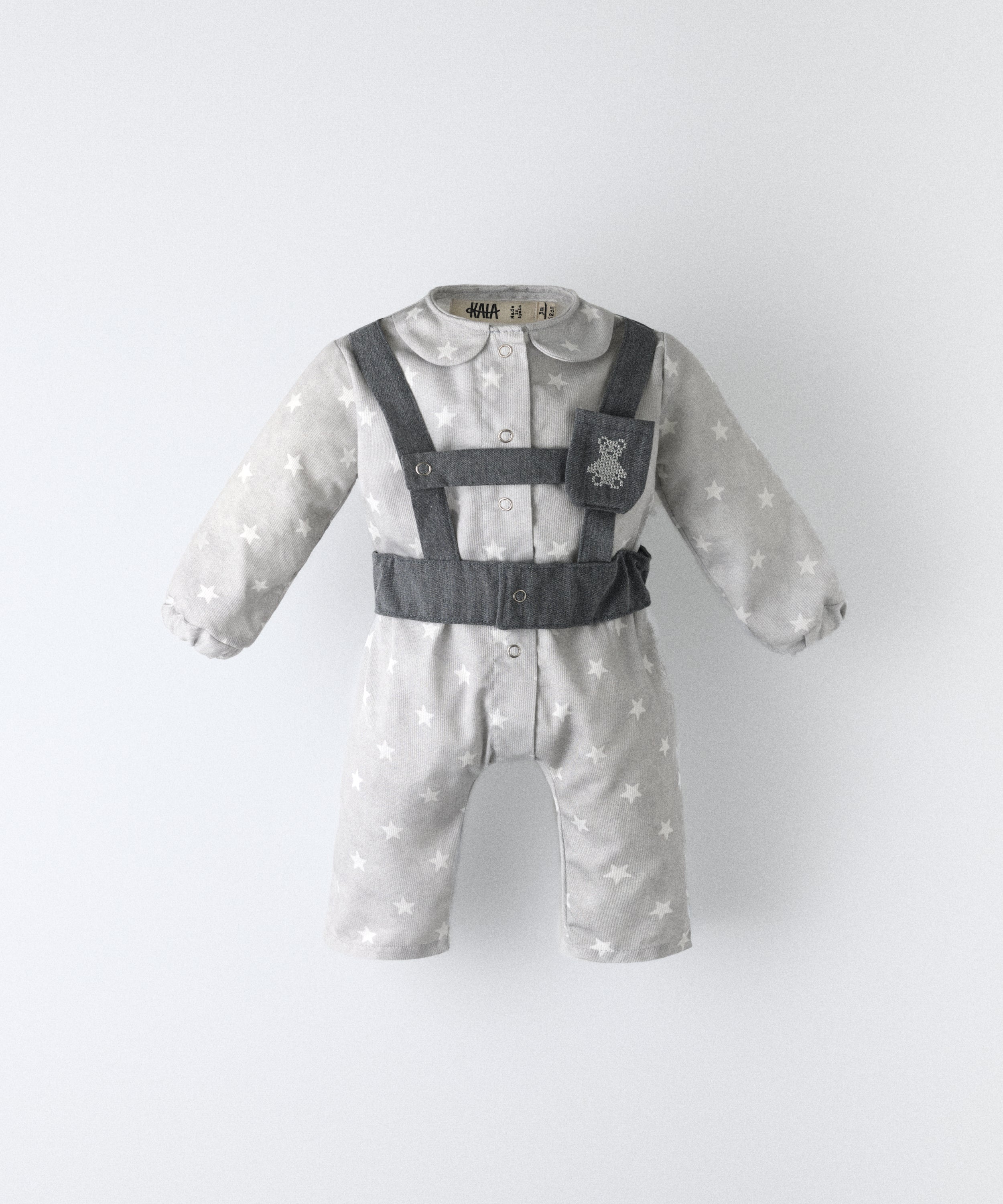 Jumpsuit bebé de piqué con estampado de estrellas y arnés en sarga denim GRS, diseño Kala.