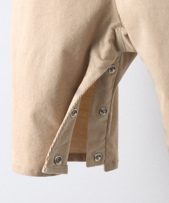 Textura de la pana elástica BCI beige y acabados artesanales del peto Kala.