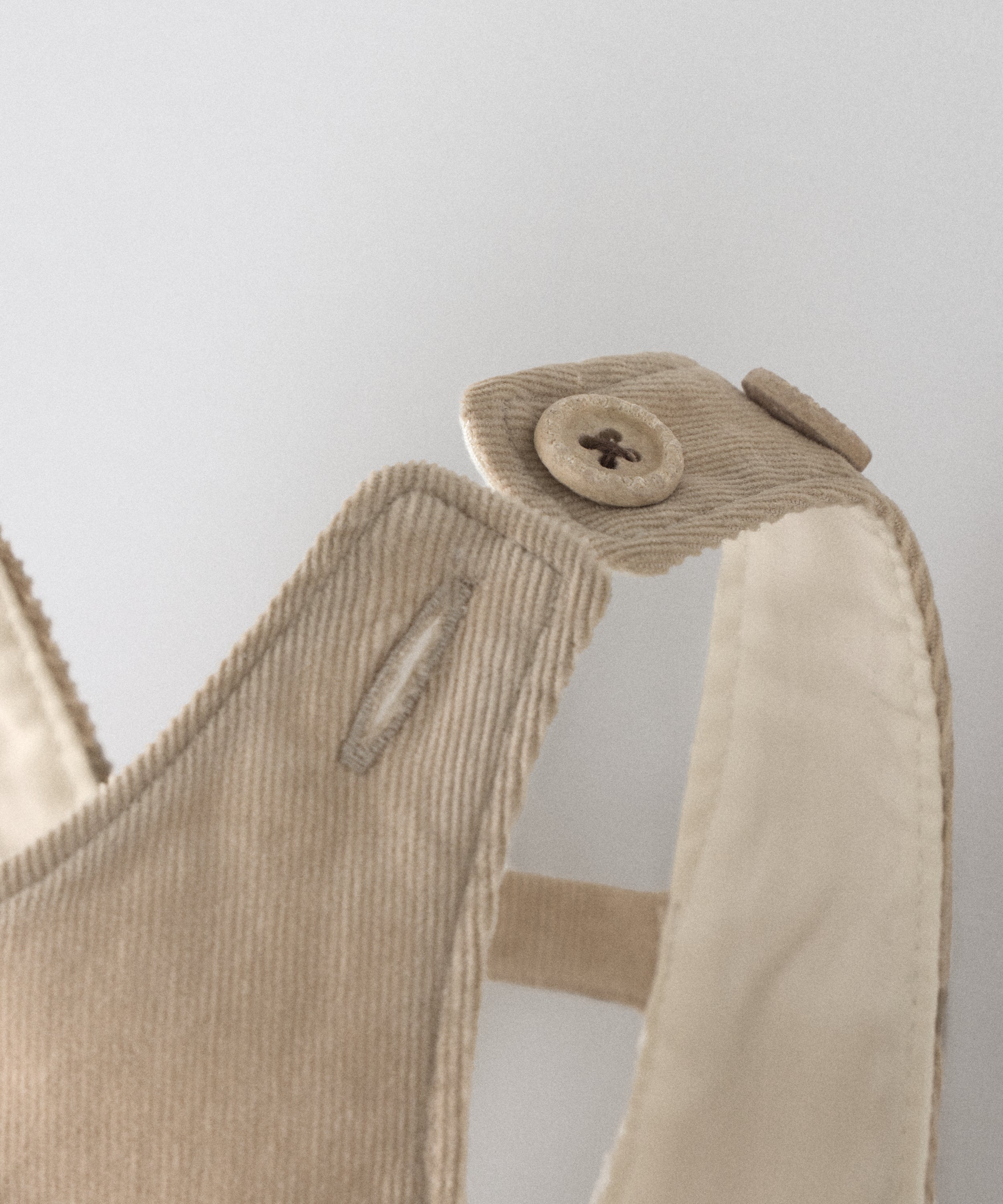 Detalle de los tirantes de pana ajustables con botones OEKO TEX