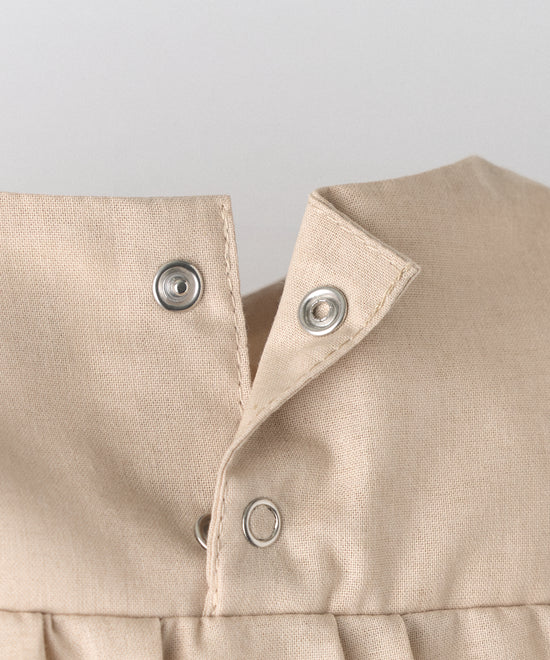 Detalle apertura espalda con cierre automáticos. Practicidad en el body Liberty en manga larga y color arena blanqueada. Confeccionado en 100 % algodón orgánico certificado GOTS. Suavidad y cuidado de la piel para tu bebé. www.kala.es