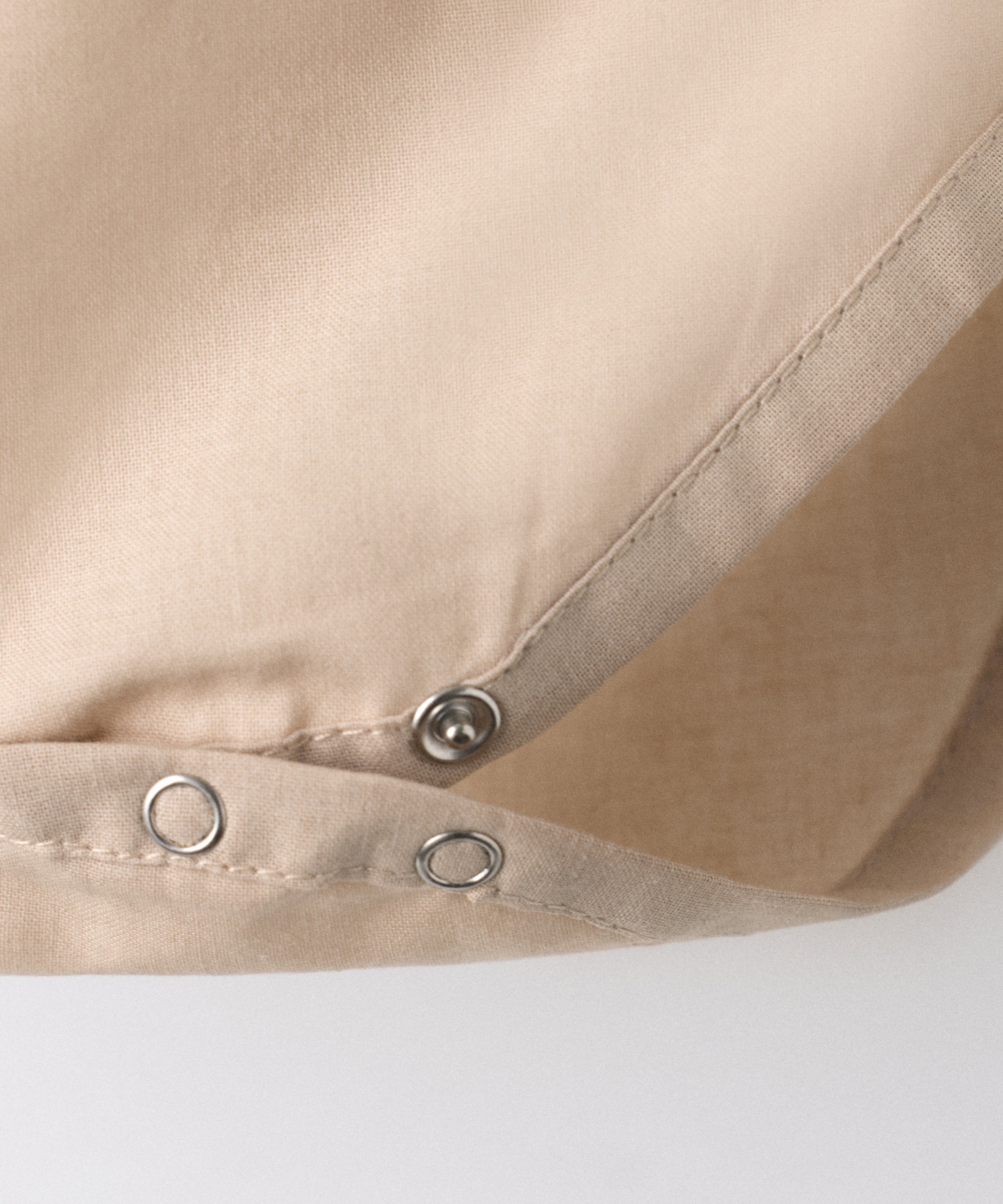 Detalle cierre automático en entrepierna del body Liberty color arena blanqueada. Confeccionado en 100 % algodón orgánico certificado GOTS. Suavidad y cuidado de la piel para tu bebé. www.kala.es