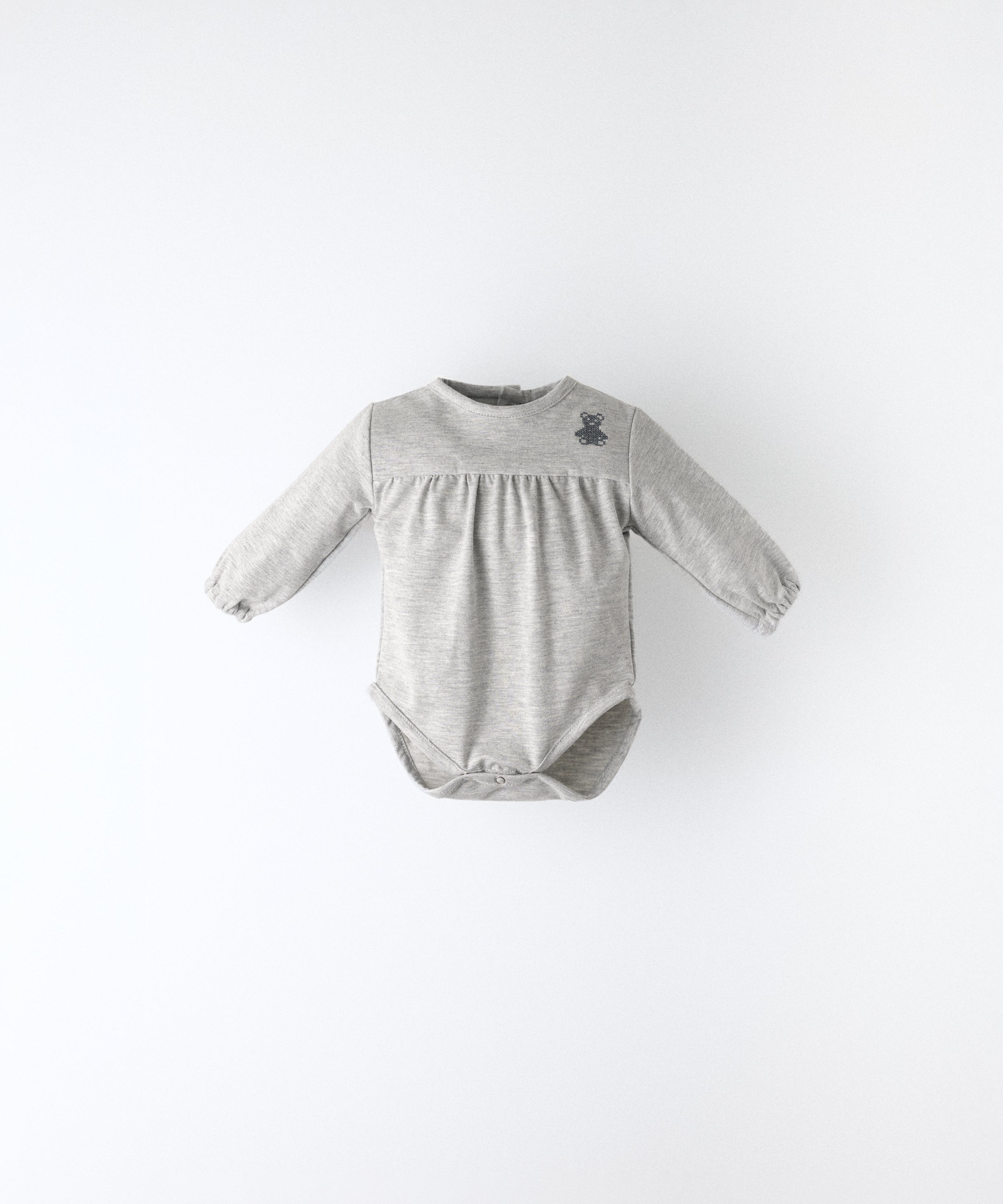 Delantero del Body Liberty en manga larga y color gris claro. Confeccionado en punto 97 % algodón orgánico + 3 % elastano, certificado GOTS. Suavidad y cuidado de la piel para tu bebé. www.kala.es