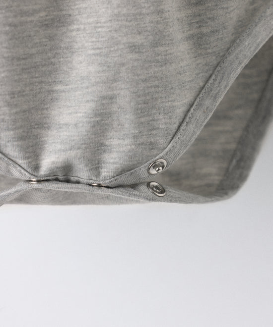 Detalle cierre entrepierna con botones automáticos. Practicidad en el body Liberty en manga larga y color gris claro. Confeccionado en punto 97 % algodón orgánico + 3 % elastano, certificado GOTS. Suavidad y cuidado de la piel para tu bebé. www.kala.es