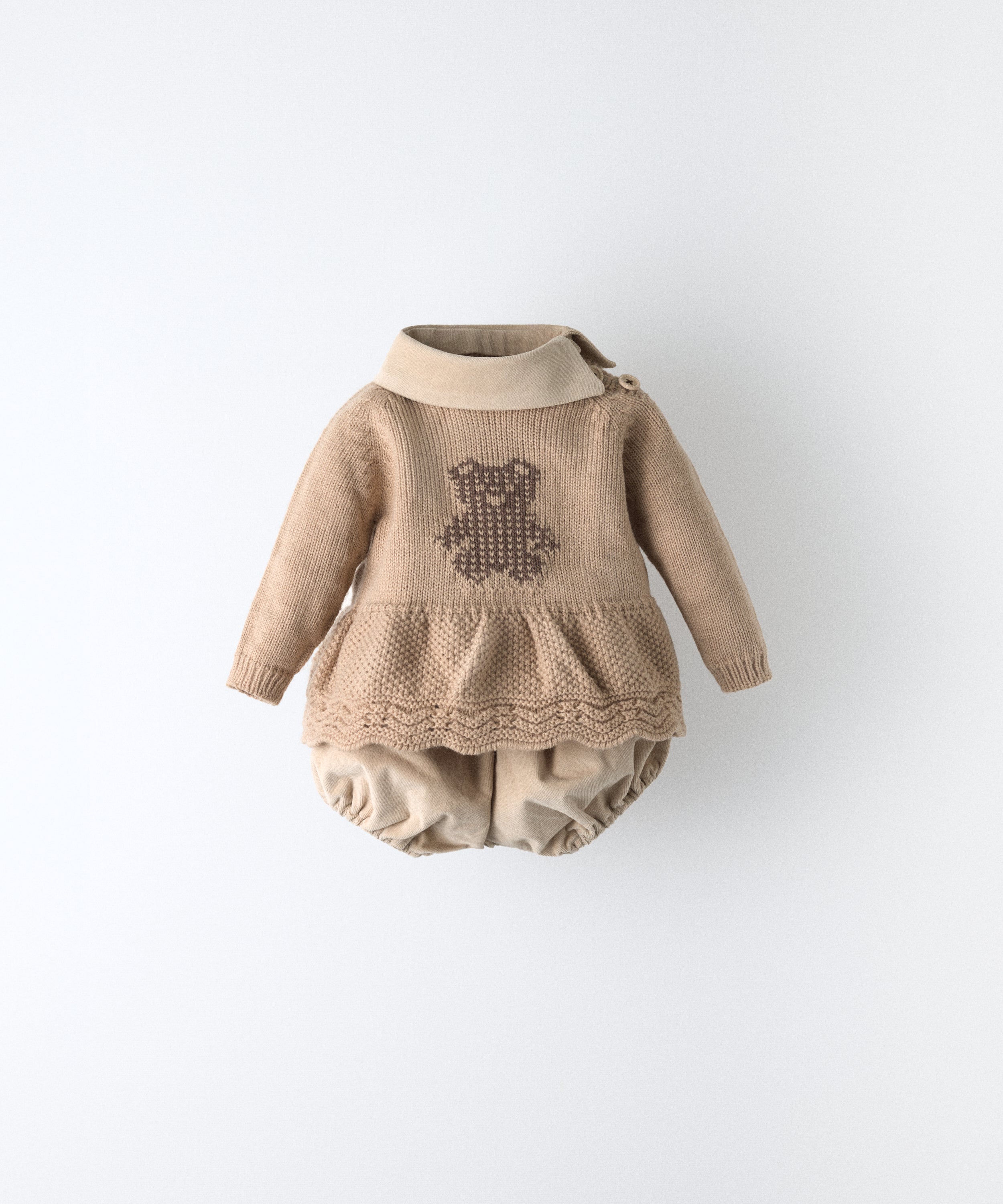 El Conjunto Bloomer consta de dos piezas. Un vestido beige de punto color con parte inferior con vuelo en punto de arroz, bajo ondulado y oso Kala en intarsia en marrón.Cuello beige en tejido de pana BCI. Delicadeza y diseño para tu bebé. www.kala.es