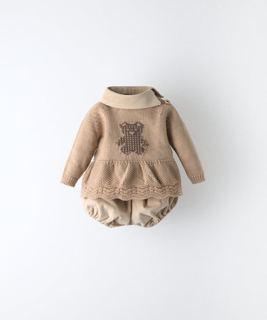 El Conjunto Bloomer consta de dos piezas. Un vestido beige de punto color con parte inferior con vuelo en punto de arroz, bajo ondulado y oso Kala en intarsia en marrón.Cuello beige en tejido de pana BCI. Delicadeza y diseño para tu bebé. www.kala.es