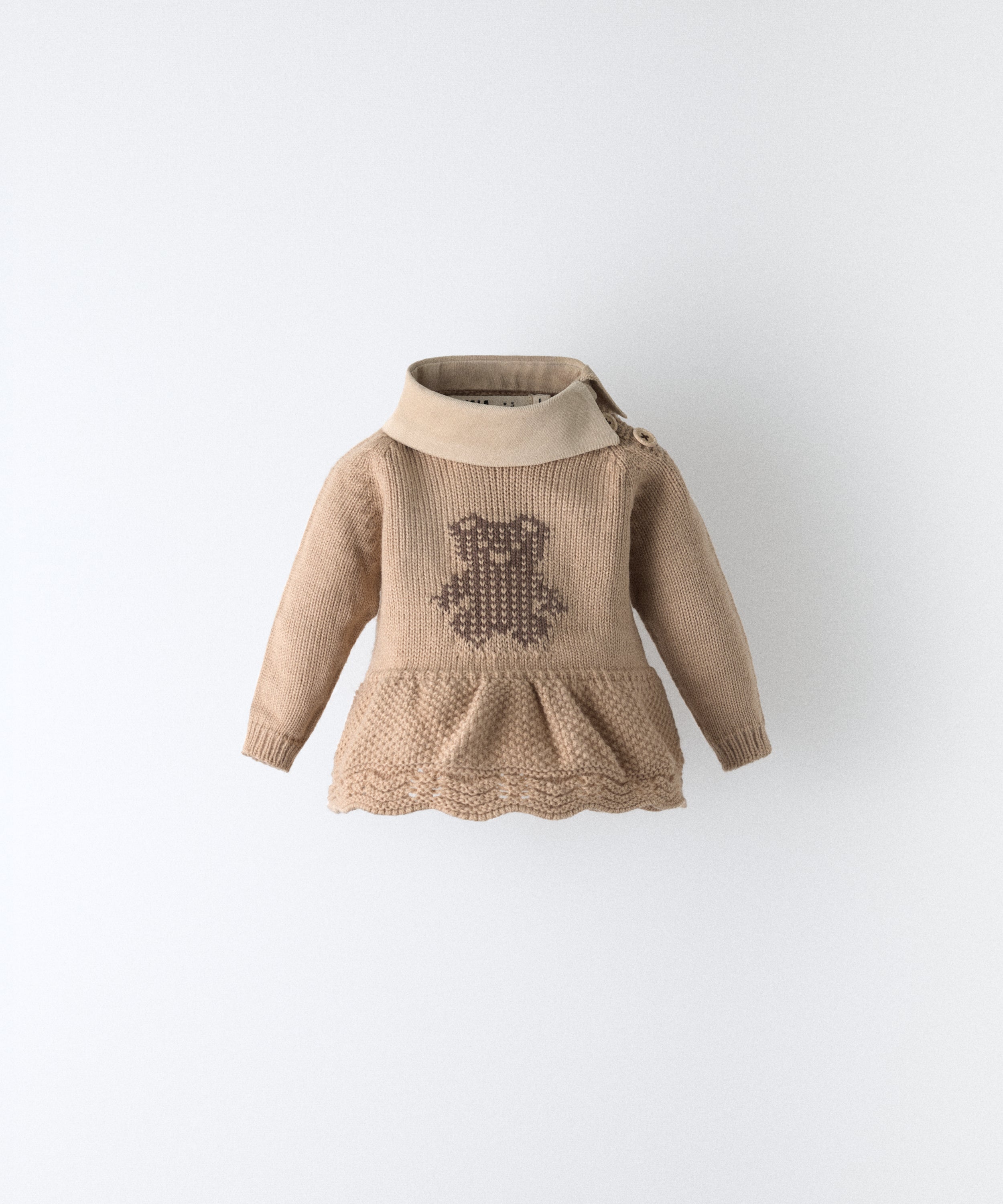 Delantero del vestido del conjunto Bloomer. Vestido beige de punto con oso kala en intarsia color marrón. Cuello en tejido de pana BCI. Delicadeza y diseño para tu bebé. www.kala.es