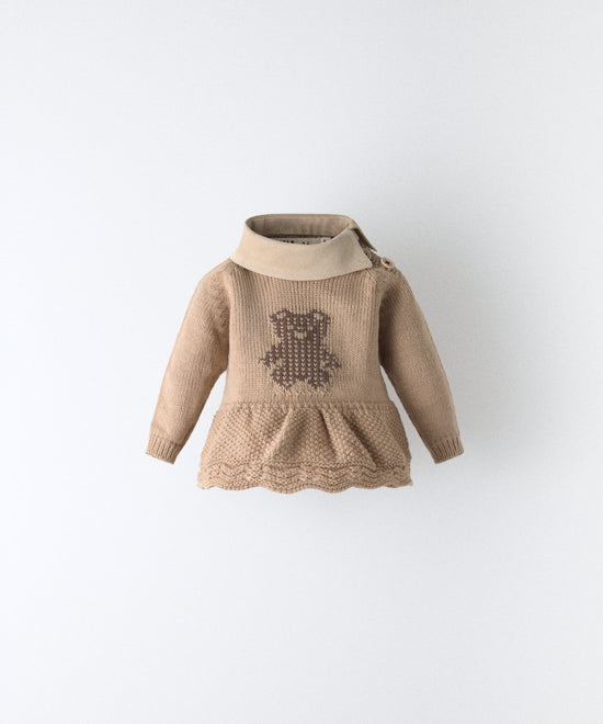 Delantero del vestido del conjunto Bloomer. Vestido beige de punto con oso kala en intarsia color marrón. Cuello en tejido de pana BCI. Delicadeza y diseño para tu bebé. www.kala.es