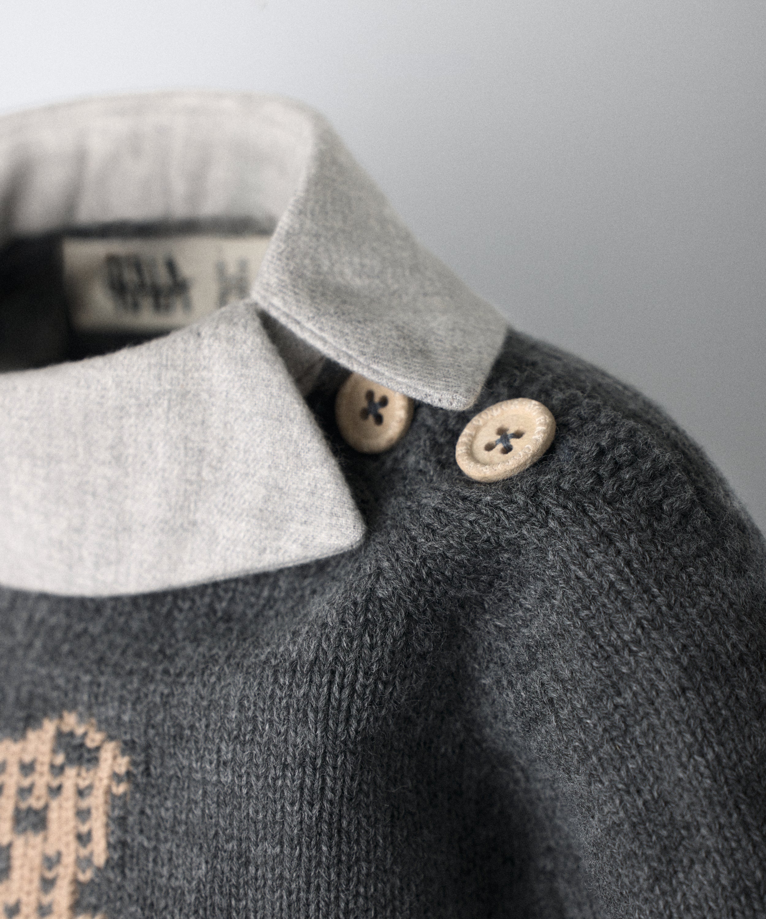 Detalle en cuello con apertura lateral y cierre en hombro con detalles mismo color que oso Kala en intarsia del vestido, beige. El Conjunto Bloomer. Gris light. www.kala.es