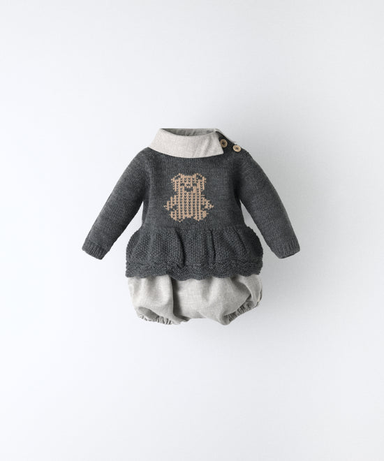 El Conjunto Bloomer consta de un vestido y un pantalón bloomer. El vestido de manga larga y punto con oso kala en intarsia color beige.Cuello camisero contrastado en sarga gris clara con apertura lateral. Mismo tejido empleado en pantalón. Autenticidad sin limites para tu bebé. www.kala.es