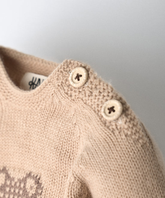 Detalle de abertura y cierre en hombro del jersey del Conjunto Strutt beige. Botones OEKO TEX al tono. Facilidad para vestir a los más pequeños. www.kala.es