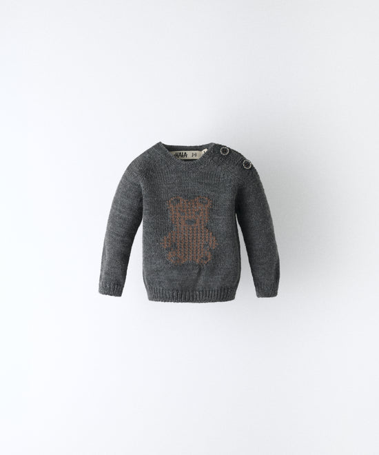 Delantero del Jersey gris oscuro del Conjunto Strutt. Diseño con oso Kala en intarsia marrón y abertura en hombro con cierre botones OEKO TEX al tono. Engomado en puños y cintura. Diseño único para tu bebé. www.kala.es