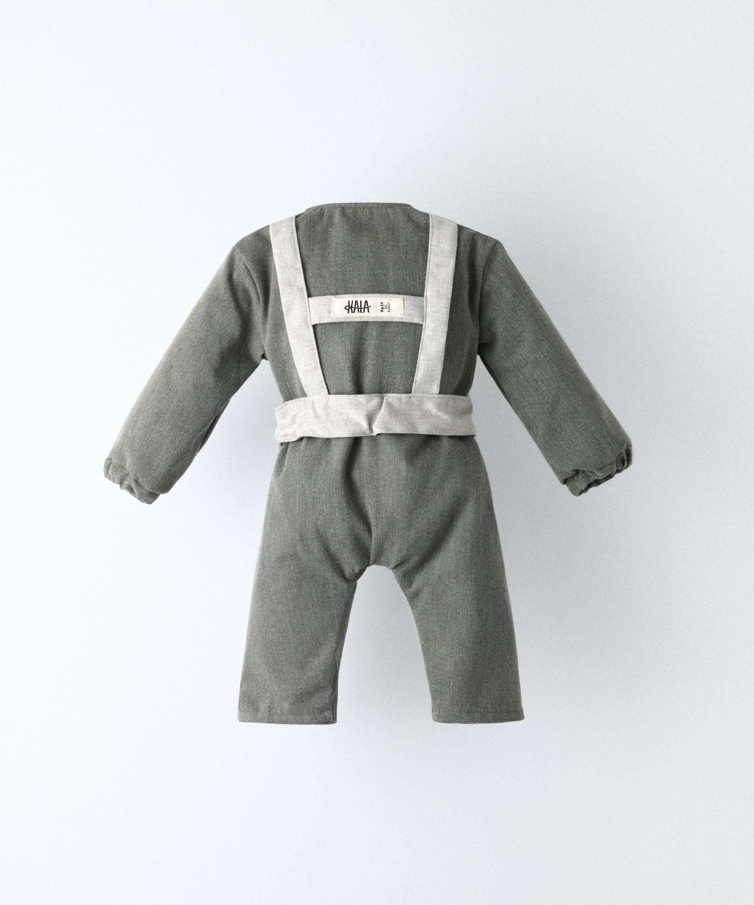 Espalda del Jumpsuit Snook verde khaki. Arnés gris claro con etiqueta visible de Kala. Diseño y atemporalidad para tu bebé. Pensado para acompañar el crecimiento con comodidad y carácter. www.kala.es