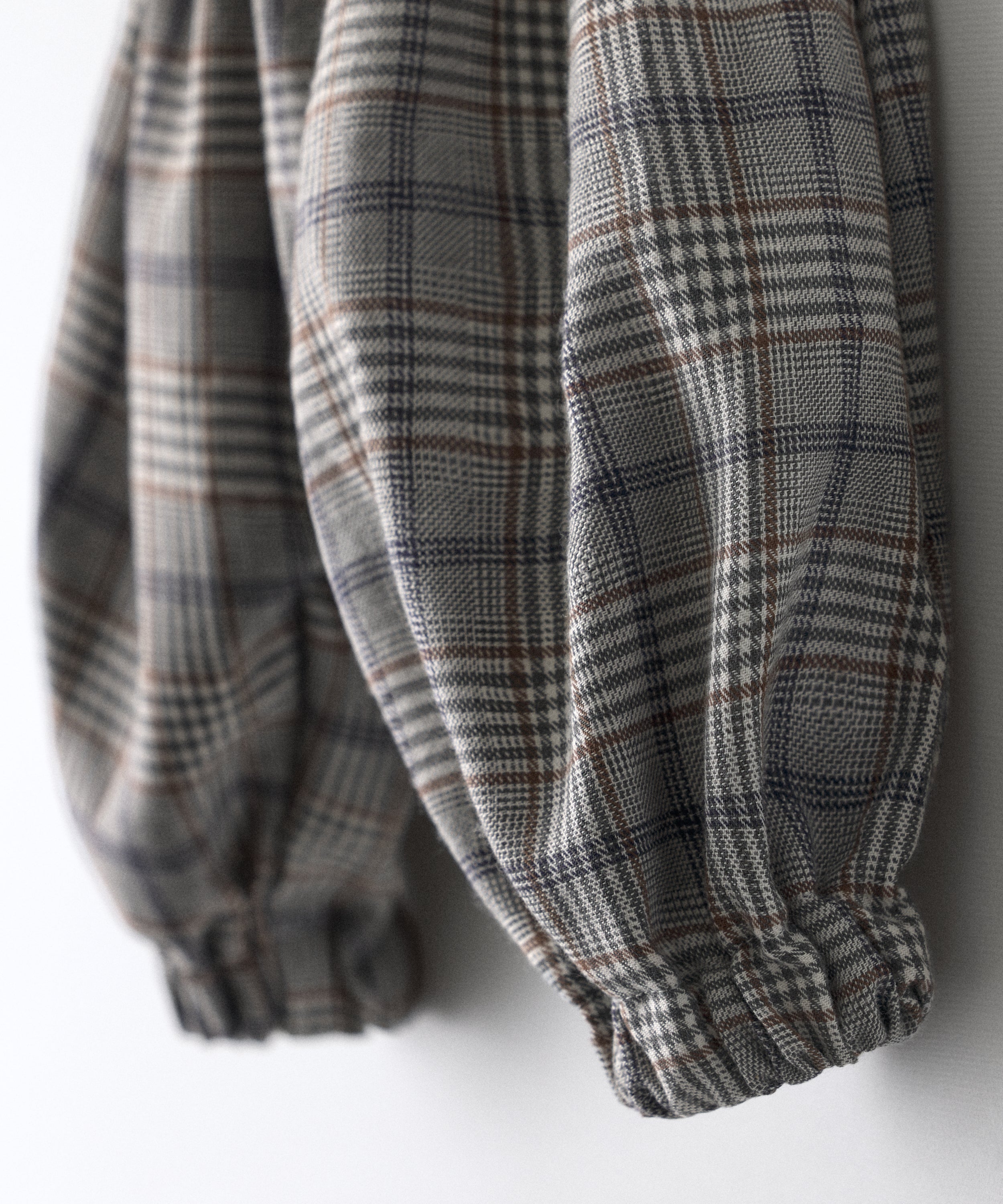 Detalle zoom de El Pantalón Balloon Bloom, tejido de cuadros combinando el marrón, azul, grises, blanco rotos. Confort y diseño para tu bebé.