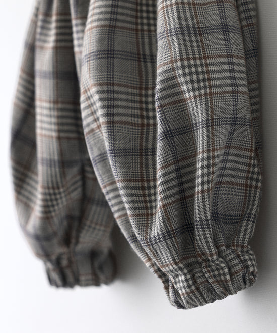 Detalle zoom de El Pantalón Balloon Bloom, tejido de cuadros combinando el marrón, azul, grises, blanco rotos. Confort y diseño para tu bebé.