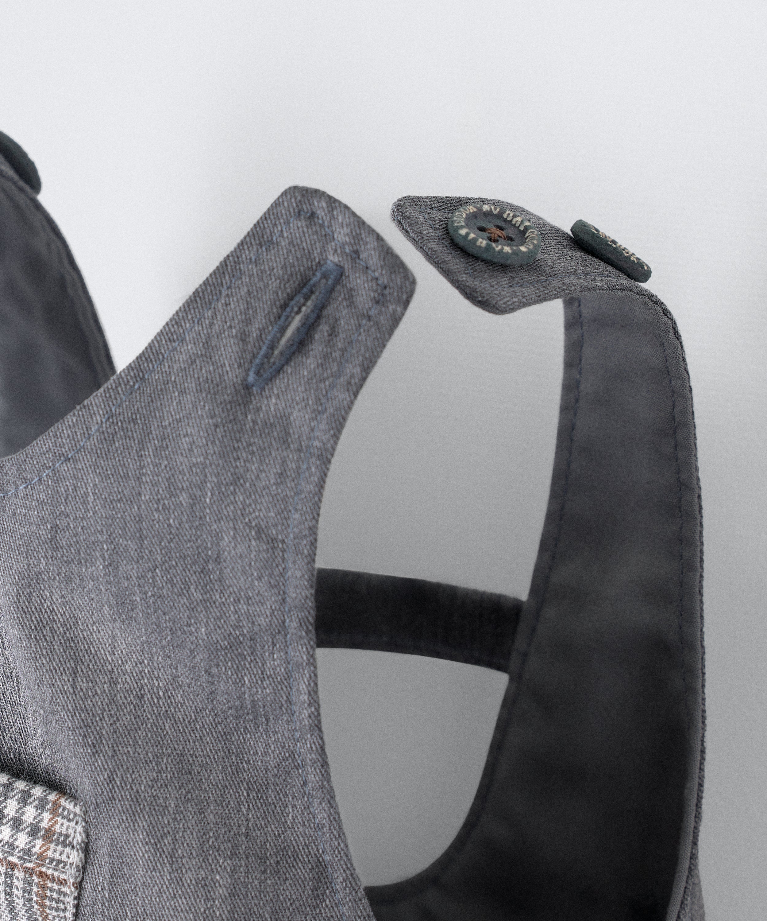 Detalle cierre de tirantes mediante botones OEKO TEX al tono. El peto Land Baby en sarga denim gris azulado es un diseño en globo, funcional y elegante para tu bebé. www.kala.es