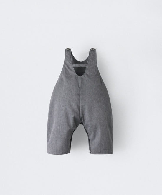 Espalda del Peto Land Baby en color gris azulado con tirantes con botones OEKO TEX. Confeccionado en sarga denim premium certificada GRS (Global Recycled Standard) y forro interior de 100 % algodón. Diseño efecto globo para la comodidad de tu bebé. www.kala.es