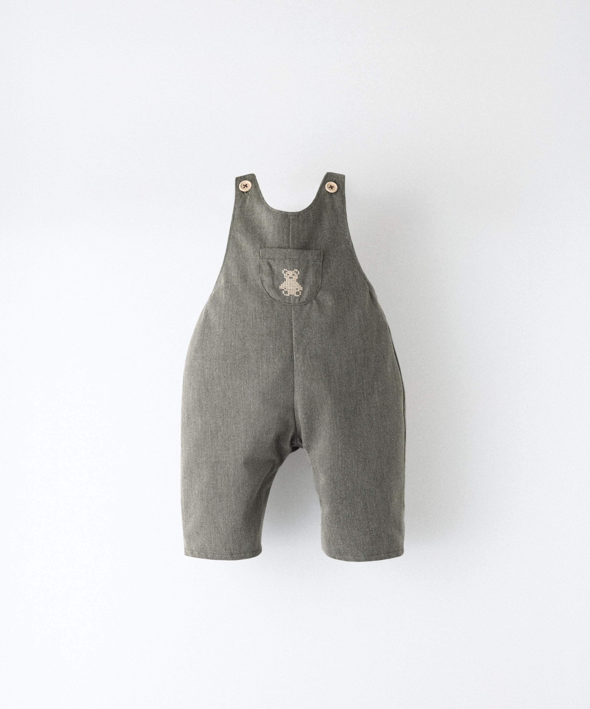 El Peto Land Baby en color verde Khaki con tirantes con botones OEKO TEX. Confeccionado en sarga denim premium certificada GRS (Global Recycled Standard) y forro interior de 100 % algodón. Diseño efecto globo para la comodiddad de tu bebé con bolsillo central con oso Kala bordado en beige. www.kala.es