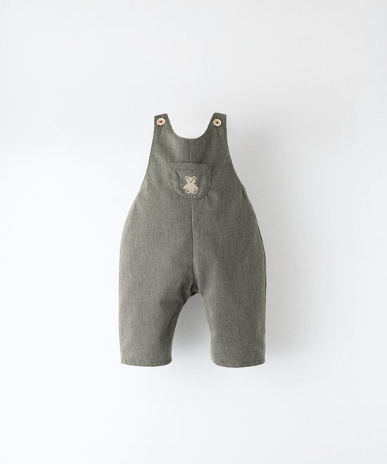 El Peto Land Baby en color verde Khaki con tirantes con botones OEKO TEX. Confeccionado en sarga denim premium certificada GRS (Global Recycled Standard) y forro interior de 100 % algodón. Diseño efecto globo para la comodiddad de tu bebé con bolsillo central con oso Kala bordado en beige. www.kala.es