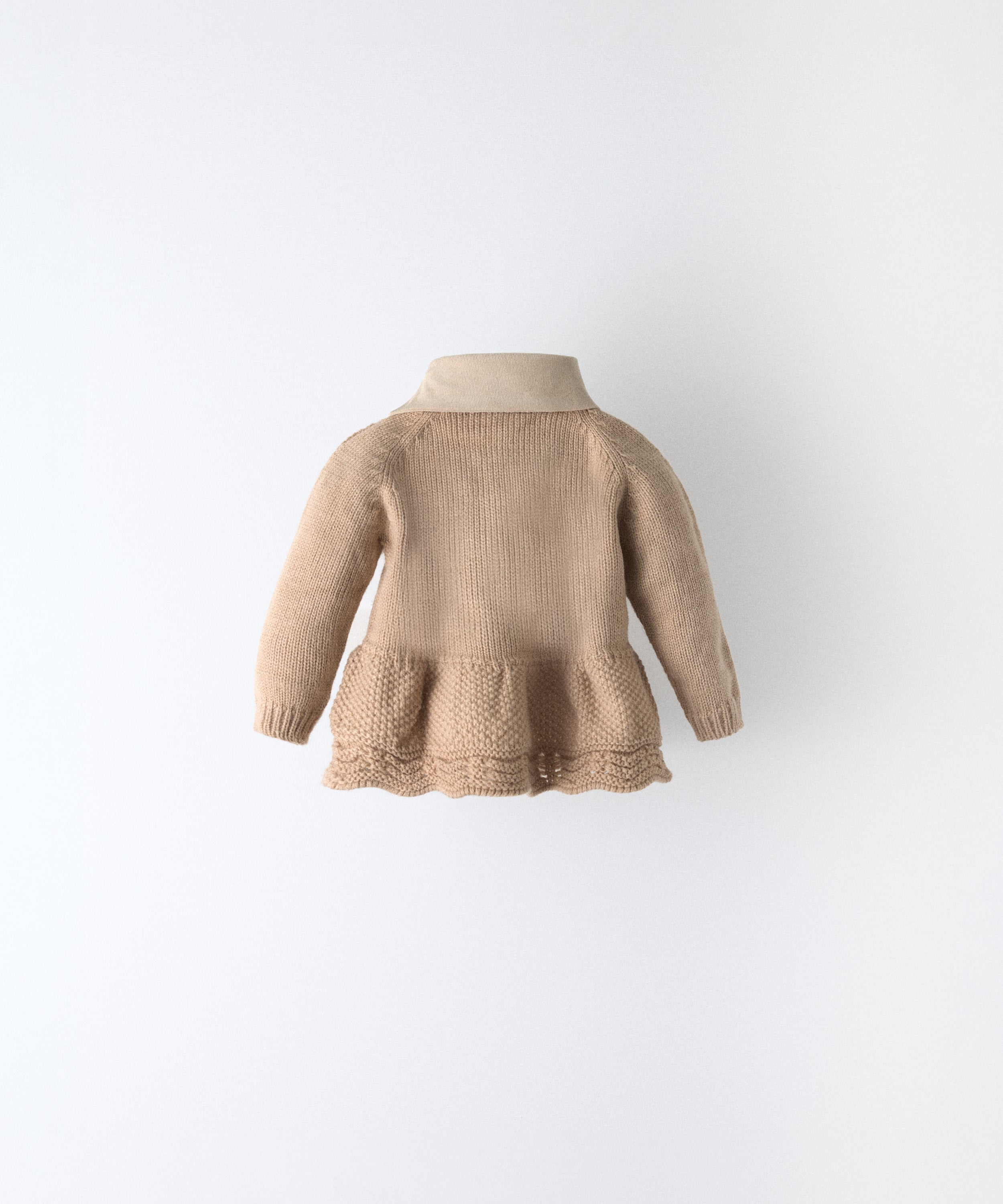 Espalda del vestido del conjunto Bloomer. Vestido de punto con parte inferior con vuelo en punto de arroz y bajo ondulado. Cuello en tejido de pana BCI. Delicadeza y diseño para tu bebé. www.kala.es