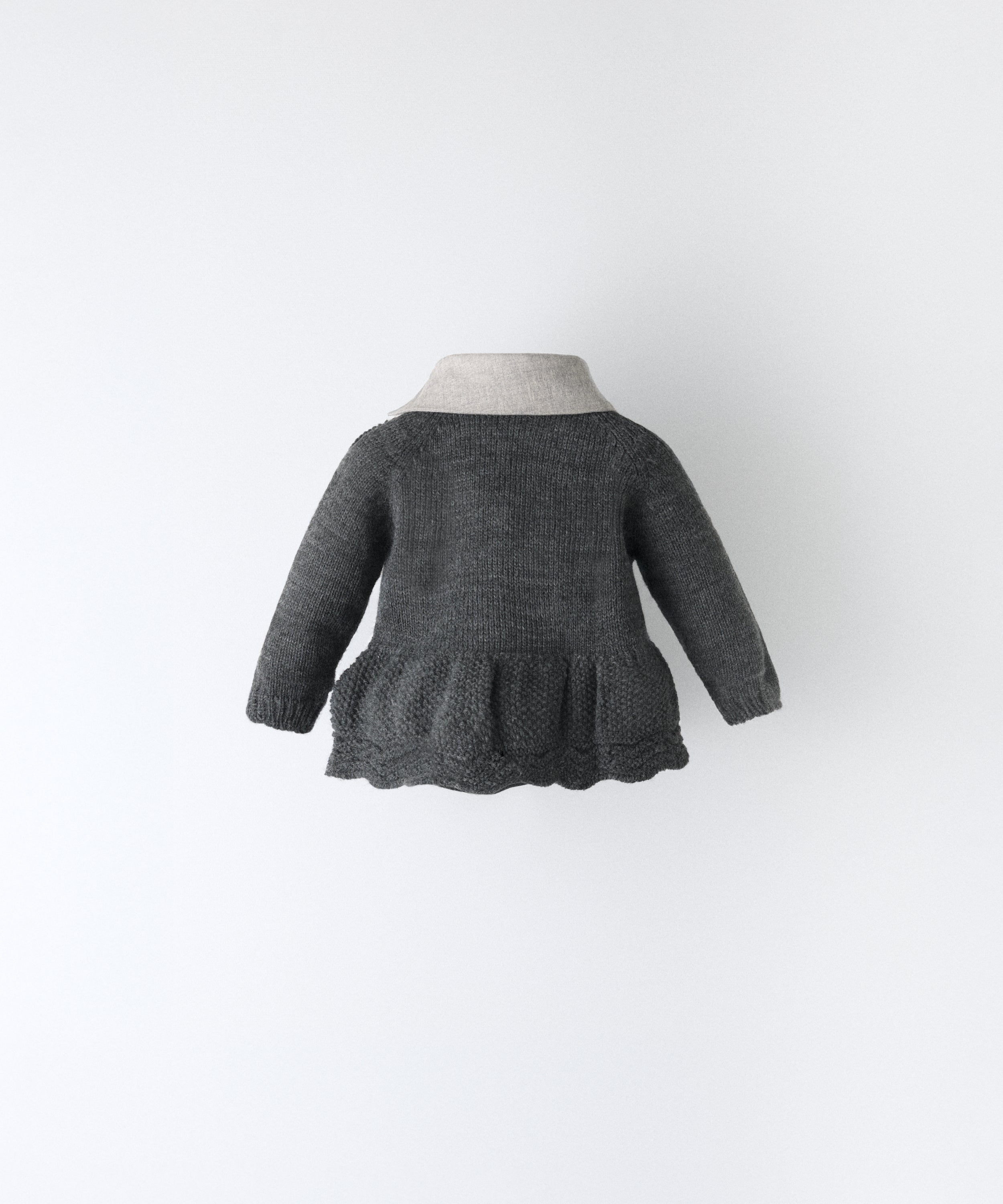 Espalda del vestido del conjunto Bloomer. Vestido en punto gris oscuro con vuelo inferior en punto de arroz y detalle ondulado en abajo. además lleva cuello contrastado con sarga gris claro.  Elegancia absoluta para tu bebé. www.kala.es