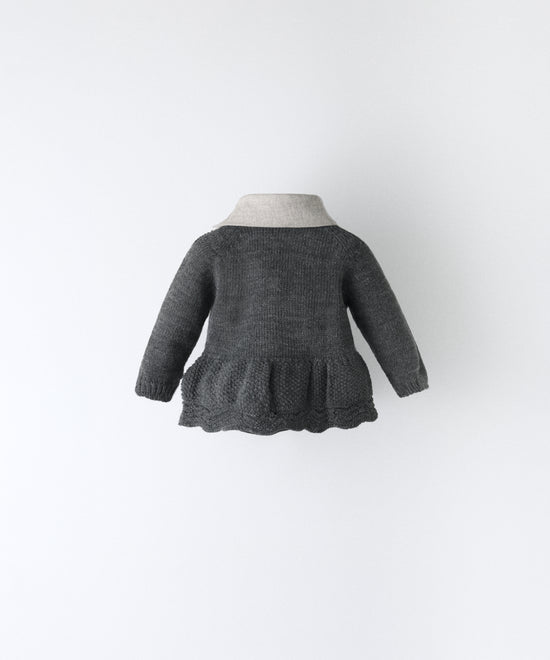 Espalda del vestido del conjunto Bloomer. Vestido en punto gris oscuro con vuelo inferior en punto de arroz y detalle ondulado en abajo. además lleva cuello contrastado con sarga gris claro.  Elegancia absoluta para tu bebé. www.kala.es