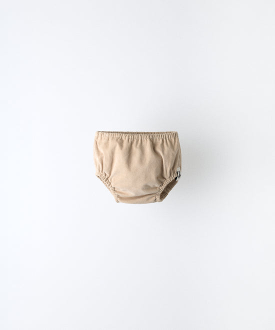 Cubrepañal del conjunto Harper en beige. Confeccionado en pana beige de algodón BCI (97 %) + 3 % elastano; forro 100 % algodón. Máximo confort para tu bebé. www.kala.es