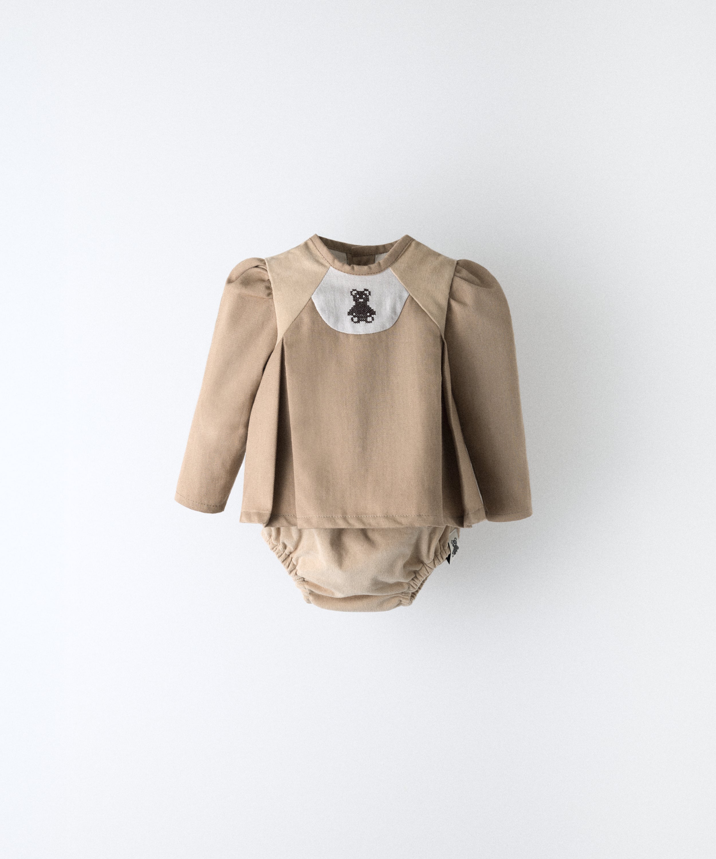 El Conjunto Harper 
Color: avellana y detalles beige
Piezas: 2 (blusón + cubrepañal) Estética y diseño premium infantil. www.kala.es