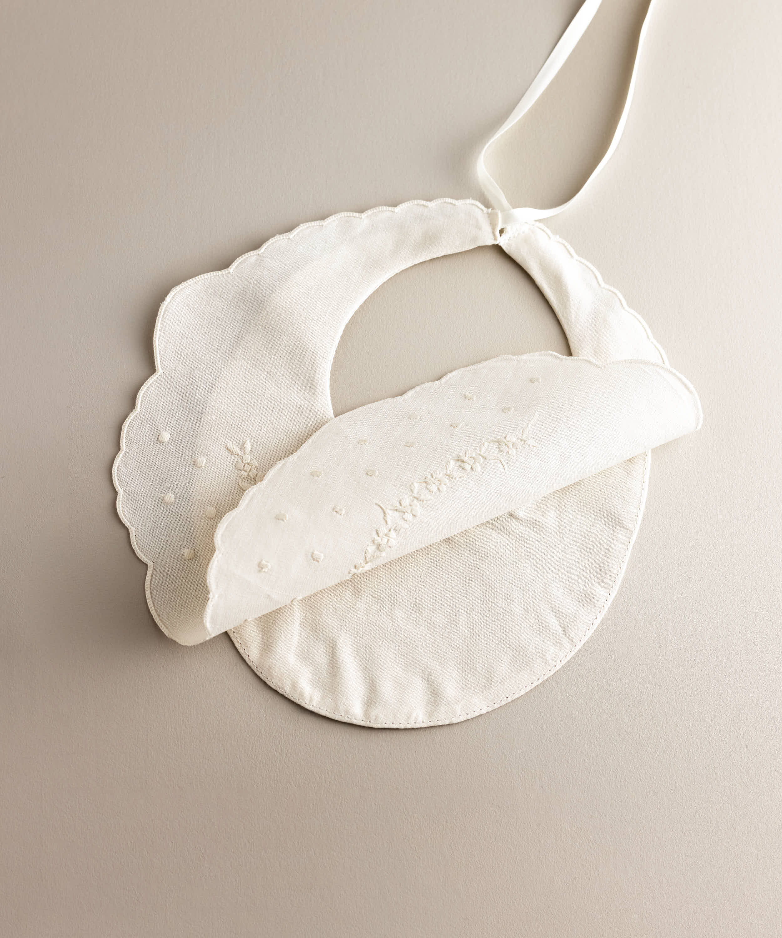Interior Babero bebé lino bordado flores blanco con bodoques.Ref.114E