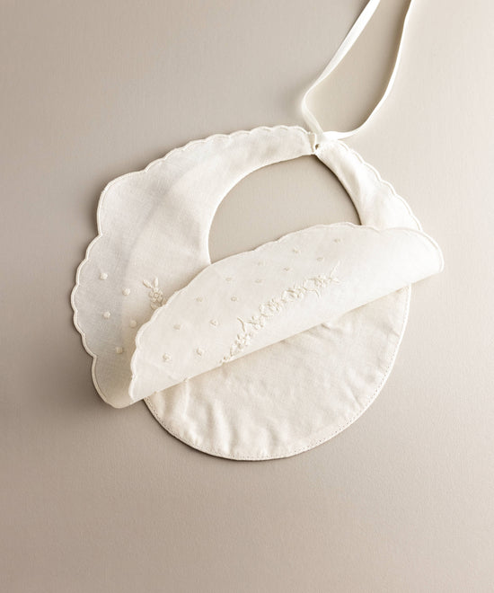 Interior Babero bebé lino bordado flores blanco con bodoques.Ref.114E