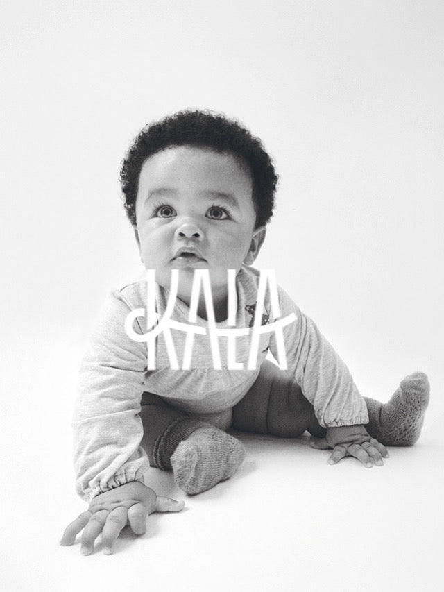 Bebé llevando Kala con una mirada auténtica, muy Kala