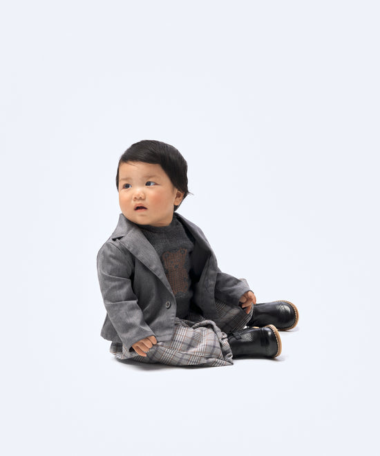 Look de ropa infantil de bebé de Kala. La bebé lleva puesto el pantalón Balloon Bloom de tejido de cuadros con Jersey del conjunto Strutt y la chaqueta Lily. Diseño, sofisticación, elegancia y atemporalidad para la infancia. 