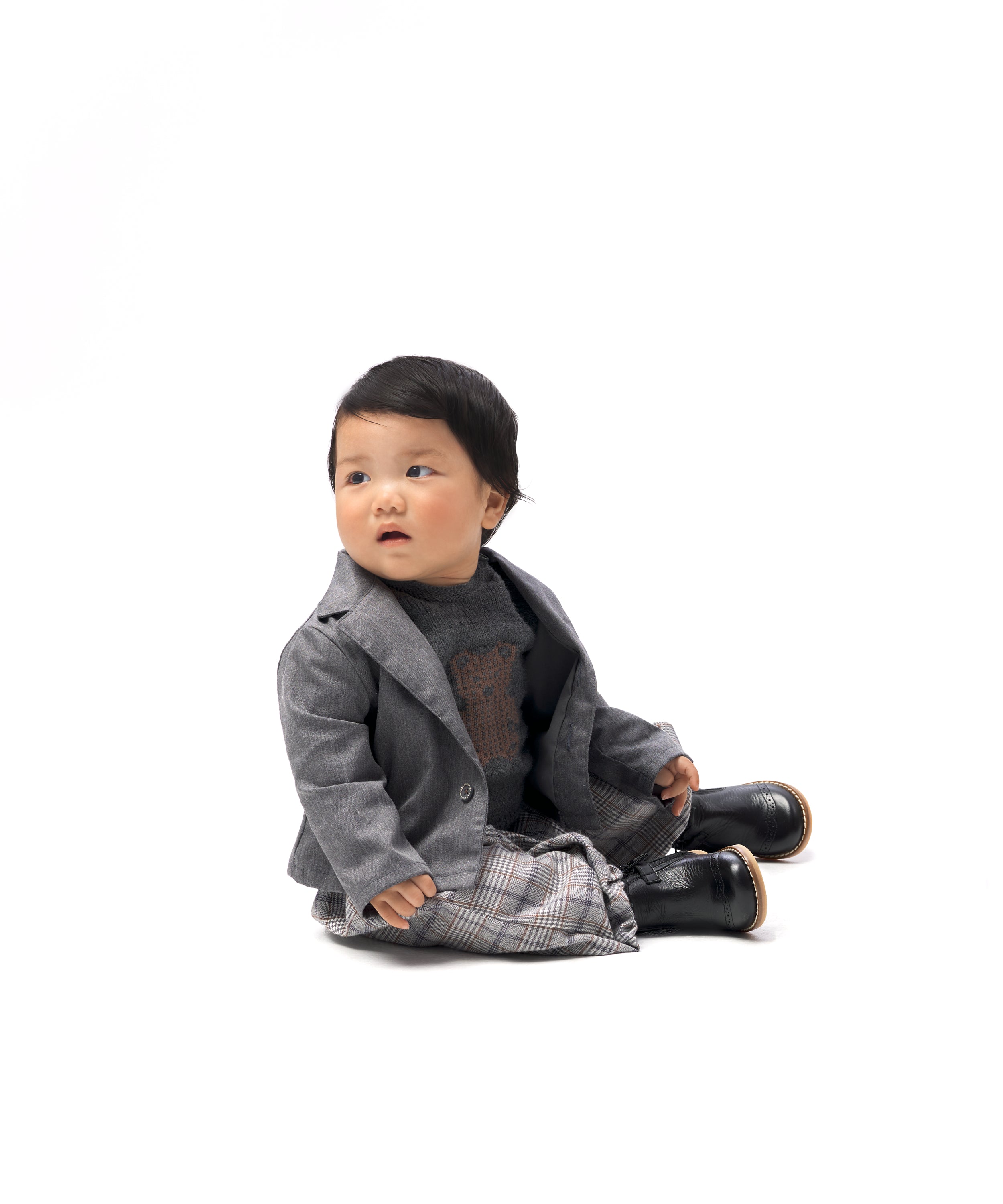 Look de ropa infantil de bebé de Kala. La bebé lleva puesto el pantalón Balloon Bloom de tejido de cuadros con Jersey del conjunto Strutt y la chaqueta Lily. Diseño, sofisticación, elegancia y atemporalidad para la infancia.