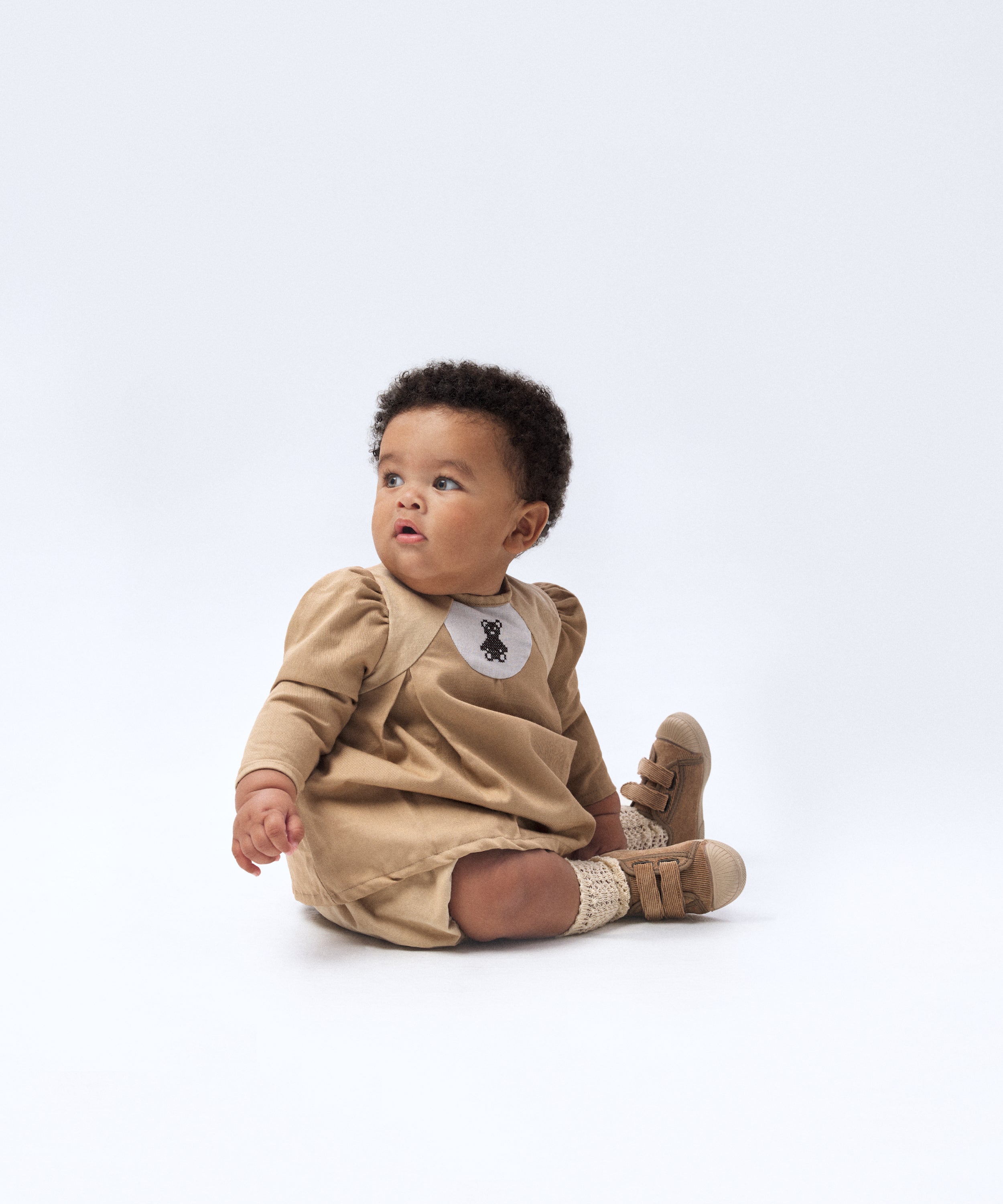 Look de ropa infantil de bebé de Kala. El bebé lleva puesto El conjunto Harper de color avellana con toques beige. Sofisticación y elegancia para la infancia. 