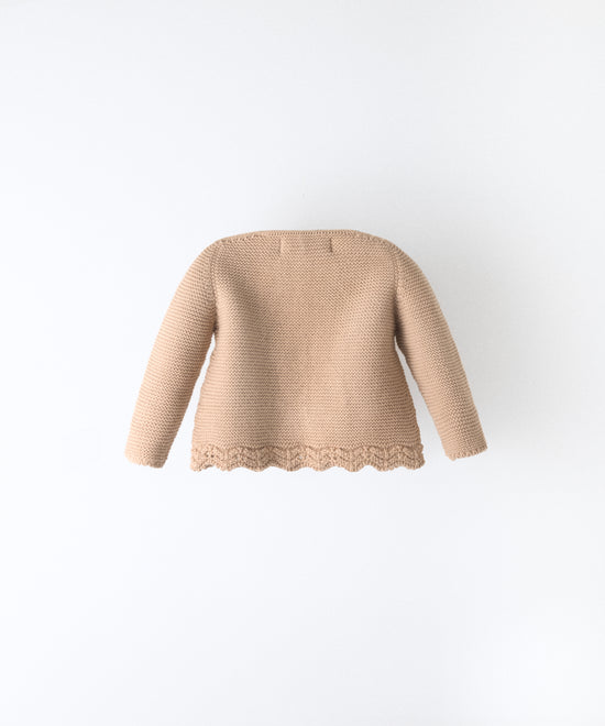 Espalda de la chaqueta Jolly beige confeccionada en punto de manga larga y bajo ondulado. 