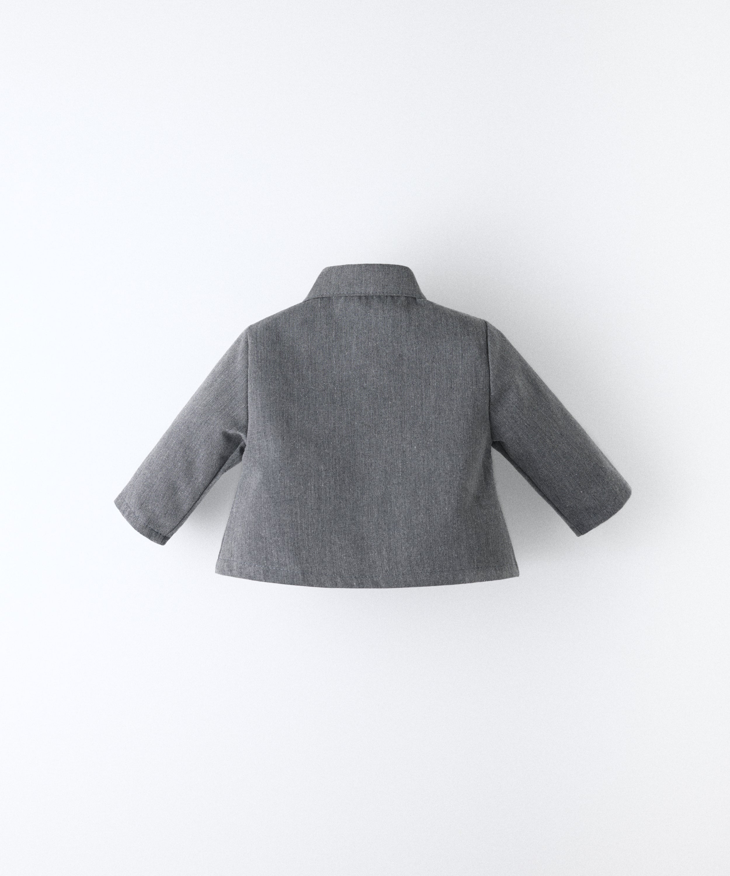 Espalda de La Chaqueta Lily gris azulada, una americana para tu bebé para celebrar la infancia. Confeccionada en sarga denim certificada GRS y forro 100% algodón. www.kala.es