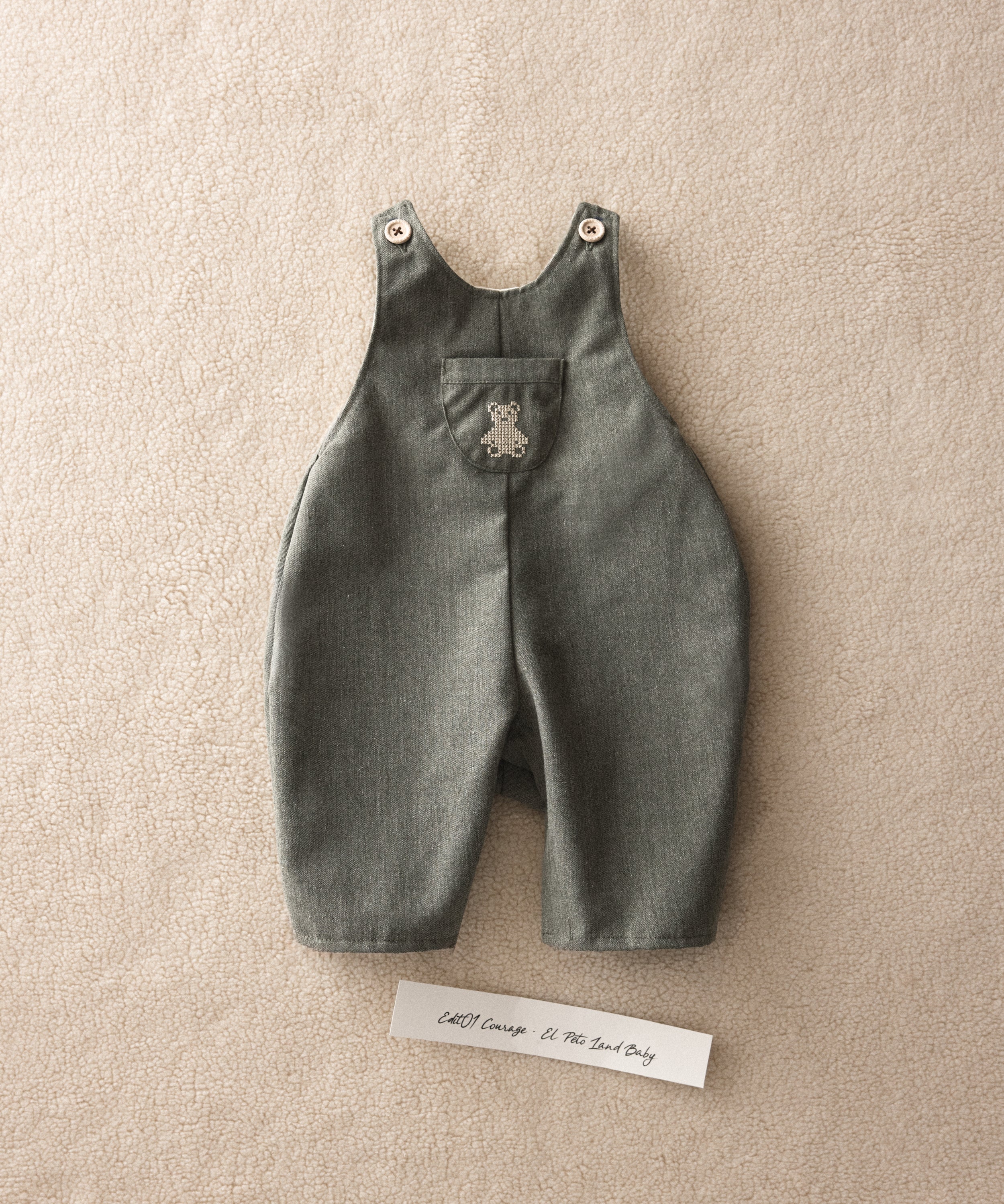 El Peto Land Baby en color verde Khaki con tirantes con botones OEKO TEX. Confeccionado en sarga denim premium certificada GRS (Global Recycled Standard) y forro interior de 100 % algodón. Diseño efecto globo para la comodiddad de tu bebé con bolsillo central con oso Kala bordado en beige. www.kala.es