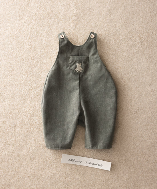 El Peto Land Baby en color verde Khaki con tirantes con botones OEKO TEX. Confeccionado en sarga denim premium certificada GRS (Global Recycled Standard) y forro interior de 100 % algodón. Diseño efecto globo para la comodiddad de tu bebé con bolsillo central con oso Kala bordado en beige. www.kala.es