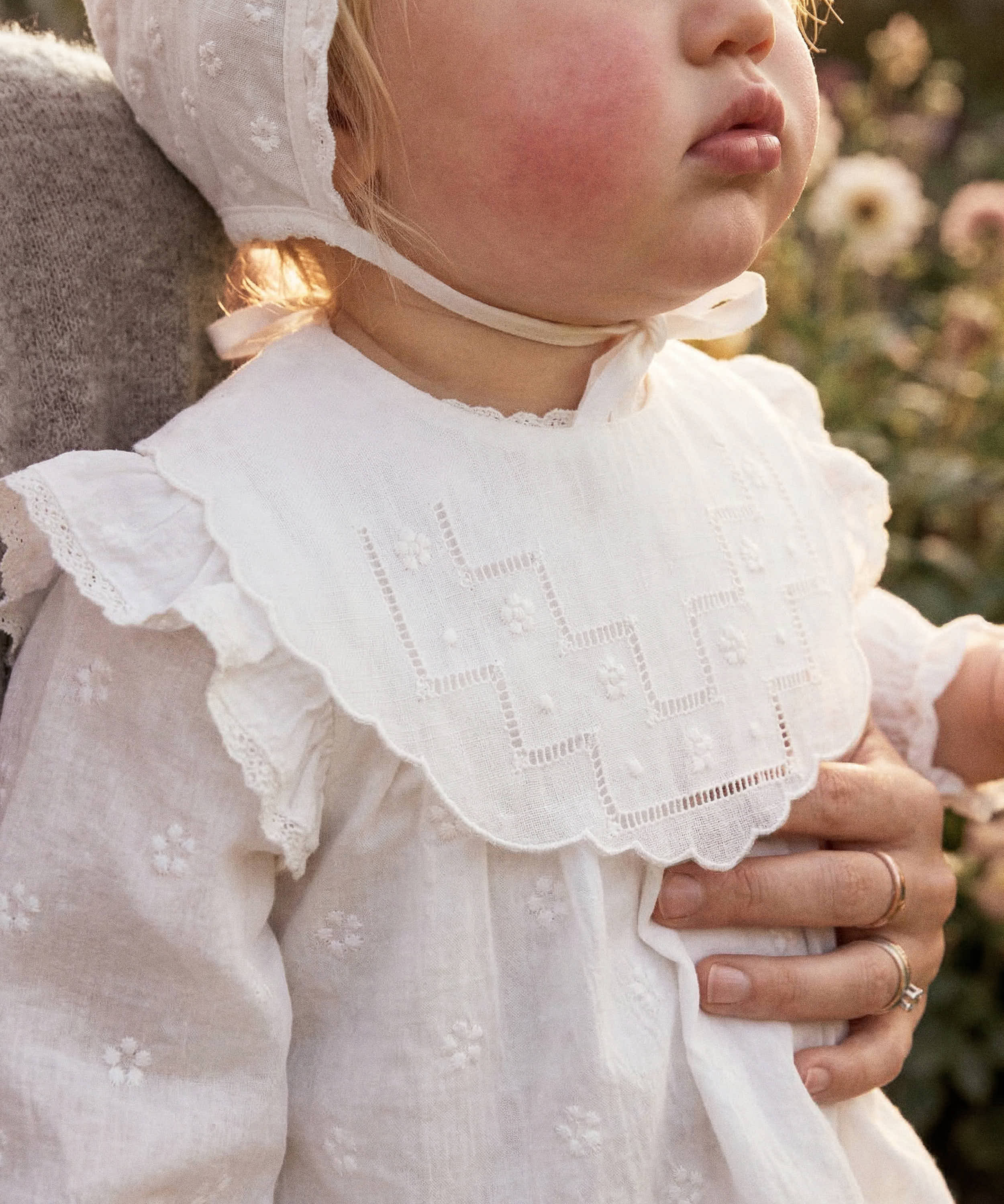 Bebé con babero lino bordado flor vainica y bodoque blanco 202W. Tinylace