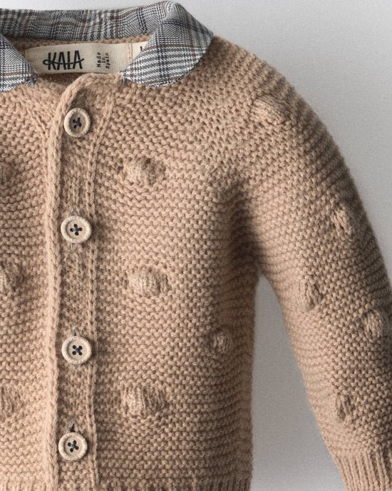 Detalle del punto de bodoques, los botones y el cuello de cuadros de la chaqueta de bebé — Kala