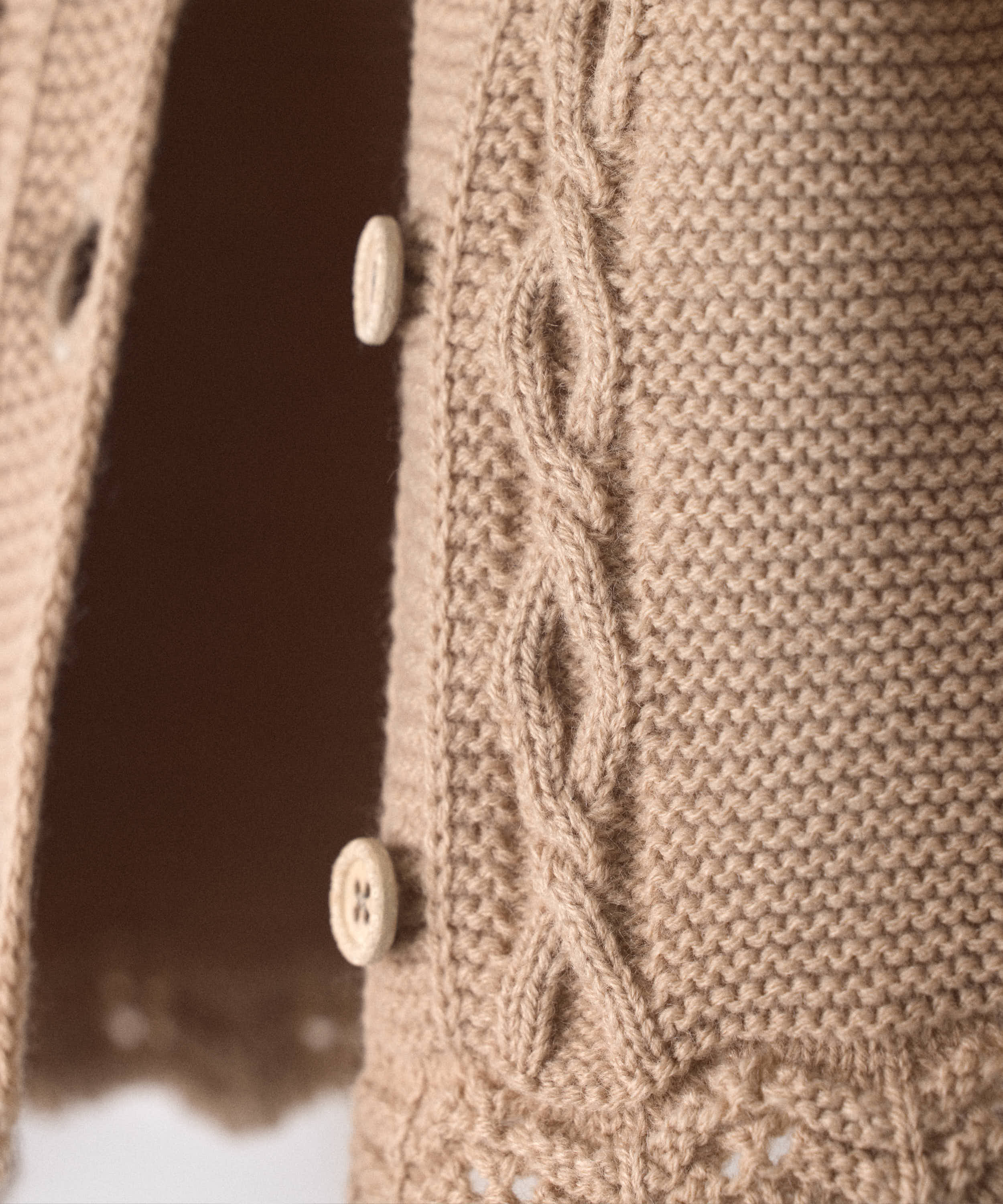Detalle de las trenzas, los botones de madera y el bajo de ondas de la chaqueta de bebé — Kala