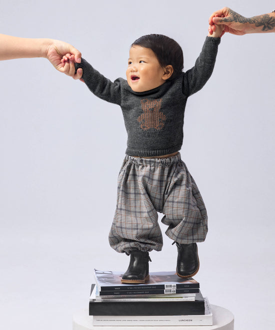 Bebé con pantalón de cuadros y jersey de osito — Kala