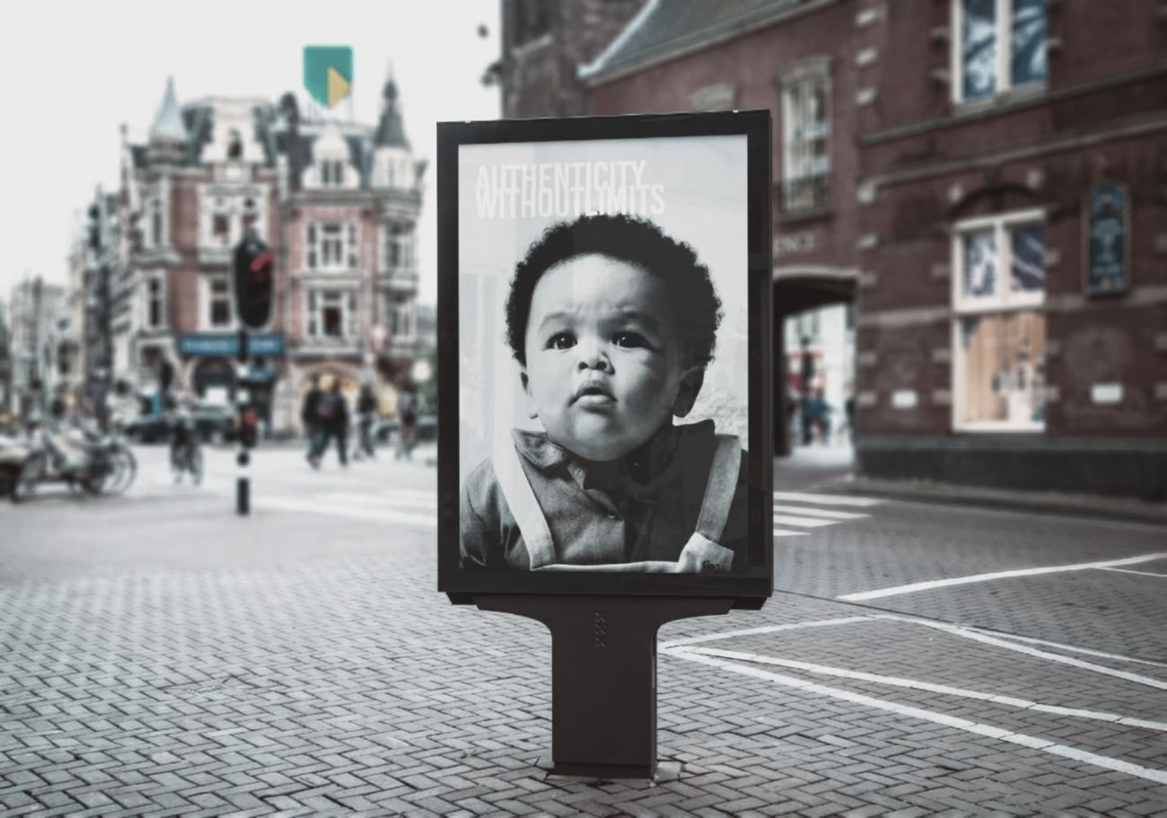 video de marquesina con un anuncio de Kala con cara de bebé vestido de la marca con tagline Authenticity without limits. Anuncio en B/N, ciudad con personas en movimiento.