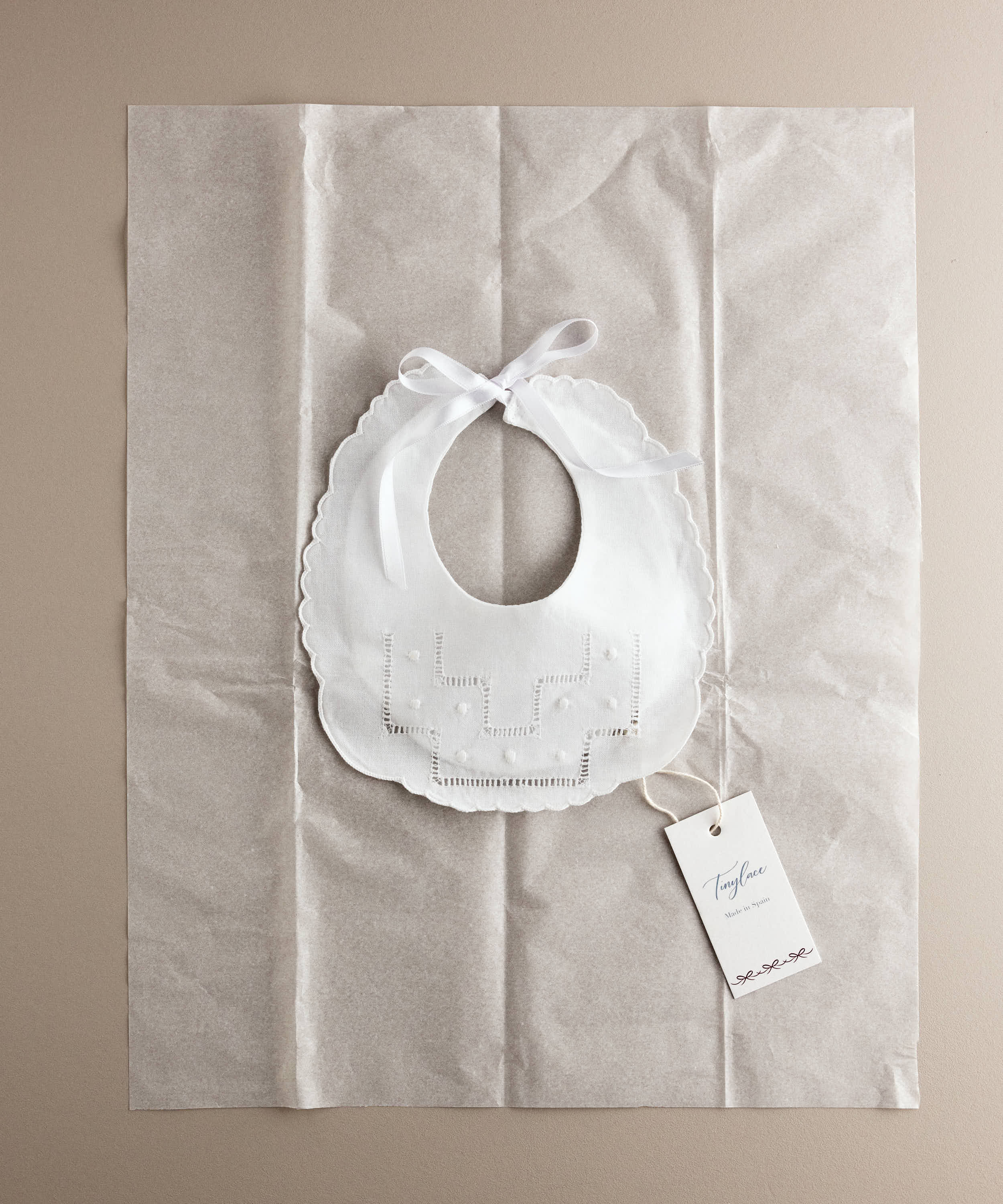 Babero de bebé de lino con vainica y bodoques en su envoltorio, ideal como regalo de nacimiento — Tinylace
