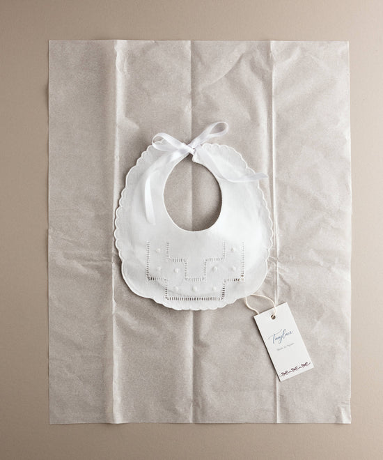Babero de bebé de lino con vainica y bodoques en su envoltorio, ideal como regalo de nacimiento — Tinylace