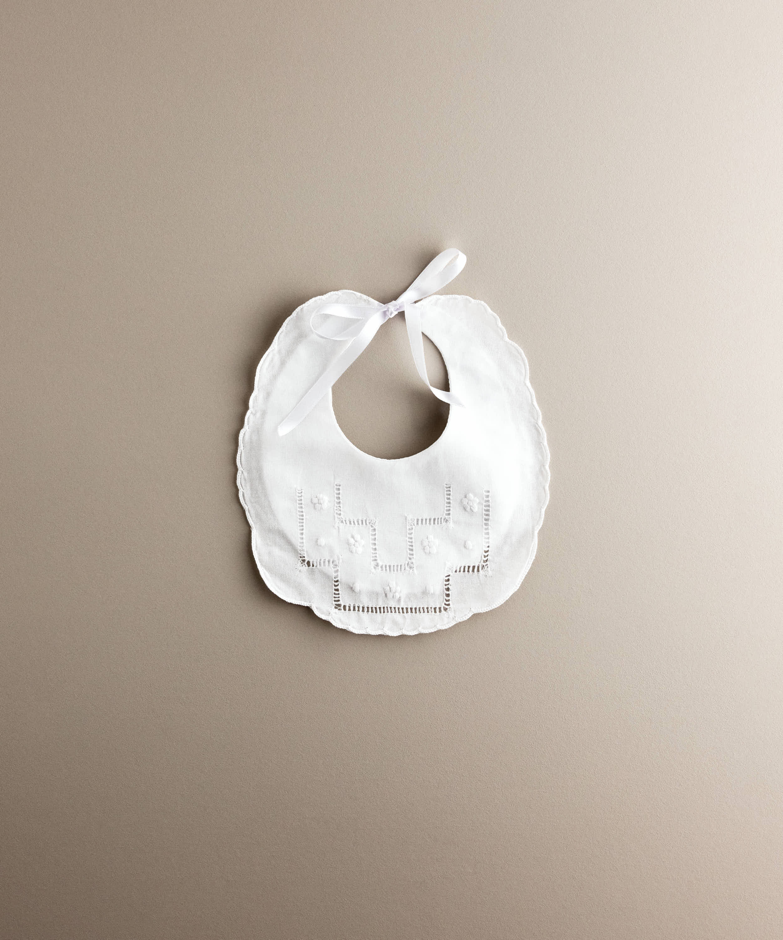 Babero de bebé de lino blanco con vainica y flores bordadas, confeccionado artesanalmente en España — Tinylace